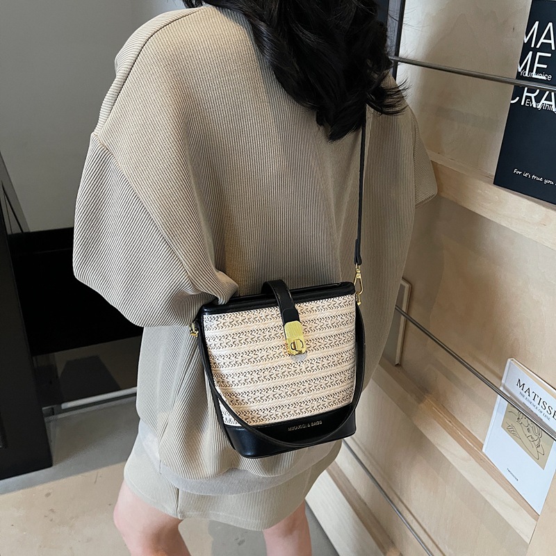 Bolso de cubo de paja de mano popular de verano 2025 nuevo bolso de mensajero tejido de vacaciones junto al mar con textura bolso femenino de todo fósforo