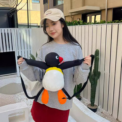 アニメのおかしな萌えはペンギンの肩を抱いてファッション的な個性のぬいぐるみを抱いて子供のカバンを包みます。