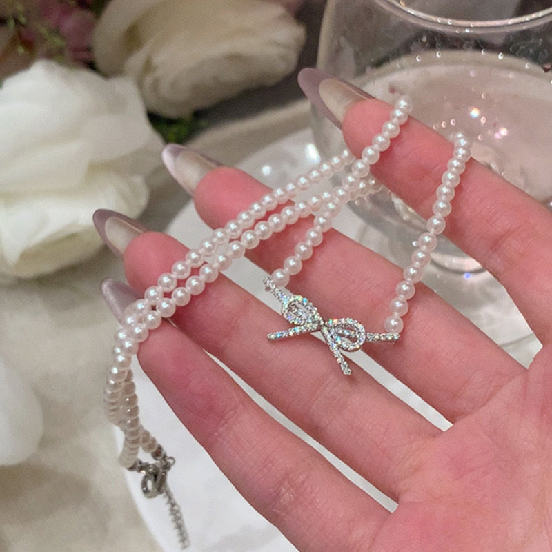 Elegant cute necklace with zircon with bow from pearl