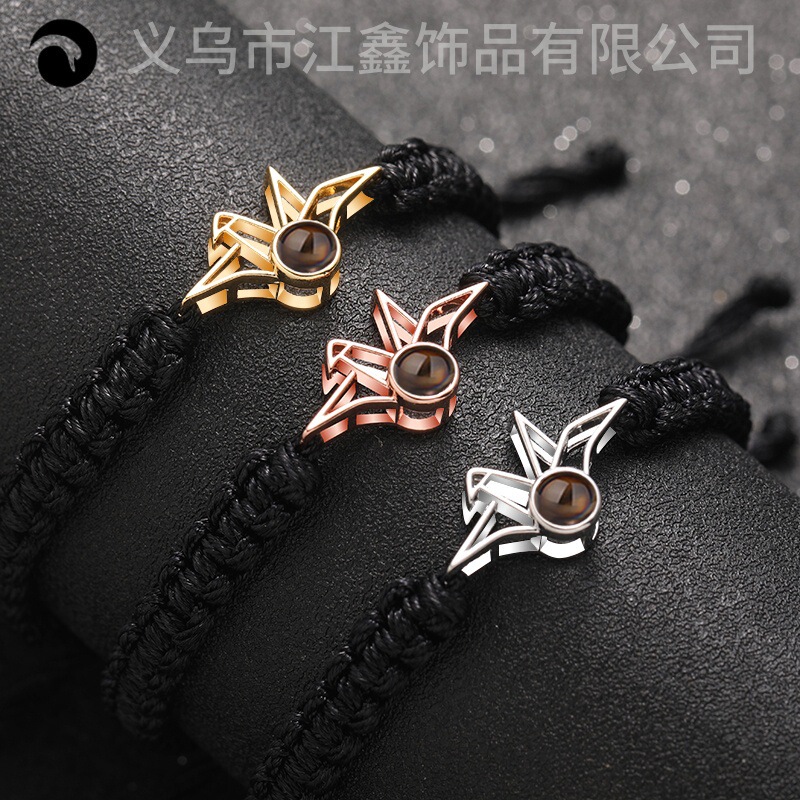 The Paper Crane's Prayer Is Tied to the Wrist with a Gentle Braided Rope Bracelet Projection in 100 Languages