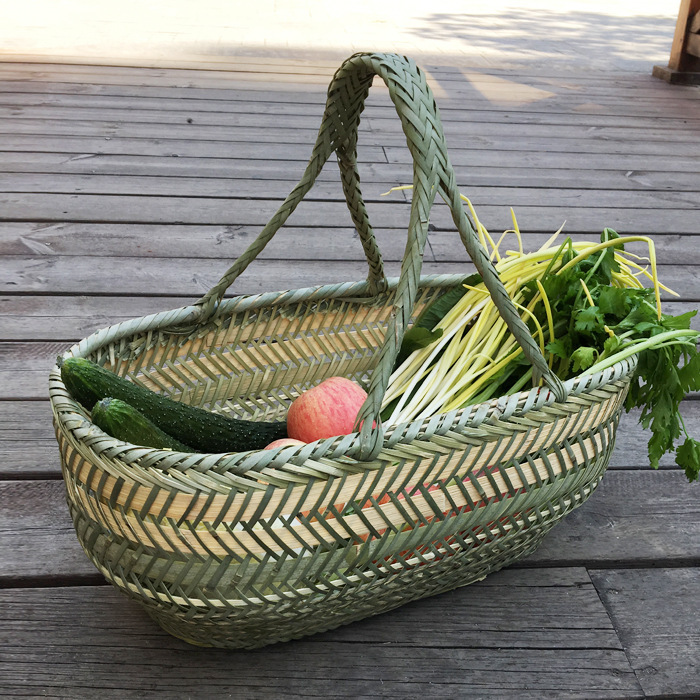 竹編みの竹かごを手に持って野菜かごを買う手作りの竹かごの果物かごの卵かごの台所収納かごの家庭用買い物かご|undefined