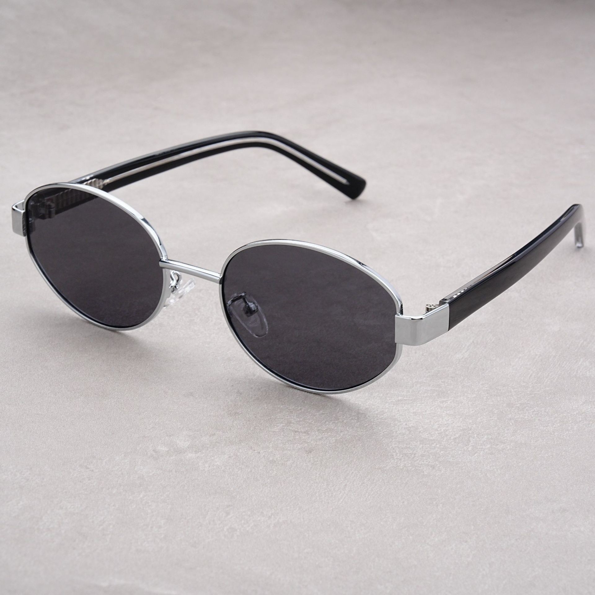 Vintage-Sonnenbrille im Retro-Stil mit strukturierter Oberfläche, dicken, ovalen, polarisierten Gläsern und UV-Schutz durch Acetat-Einsätze an den Bügeln._voghion.com