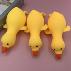 つまんで楽しいおもちゃのかわいいアヒルがアヒルのガチョウに向かってゆっくりと弾きます。