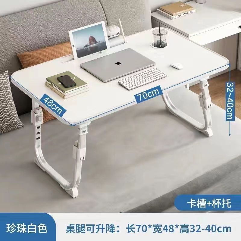ベッドの上の小さい机のノートパソコンの机の上で折り畳みます。|undefined