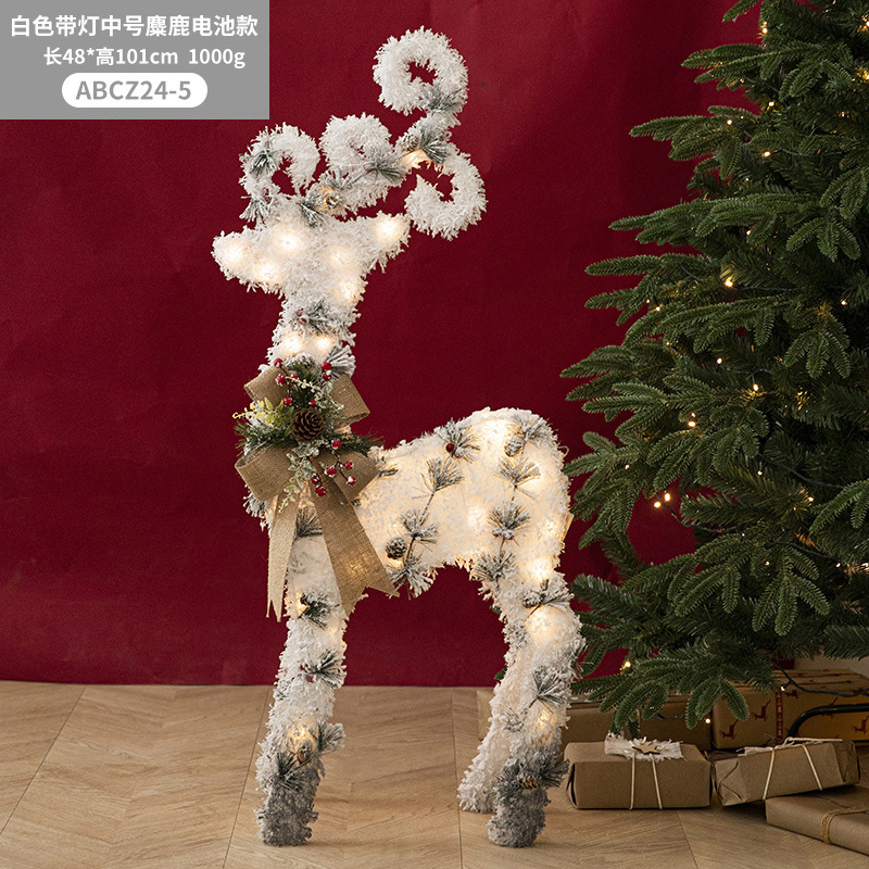 Decoraciones navideñas de muñecos de nieve, adornos de escaparate con una escena de renos de peluche blancos brillantes para la Nochebuena.