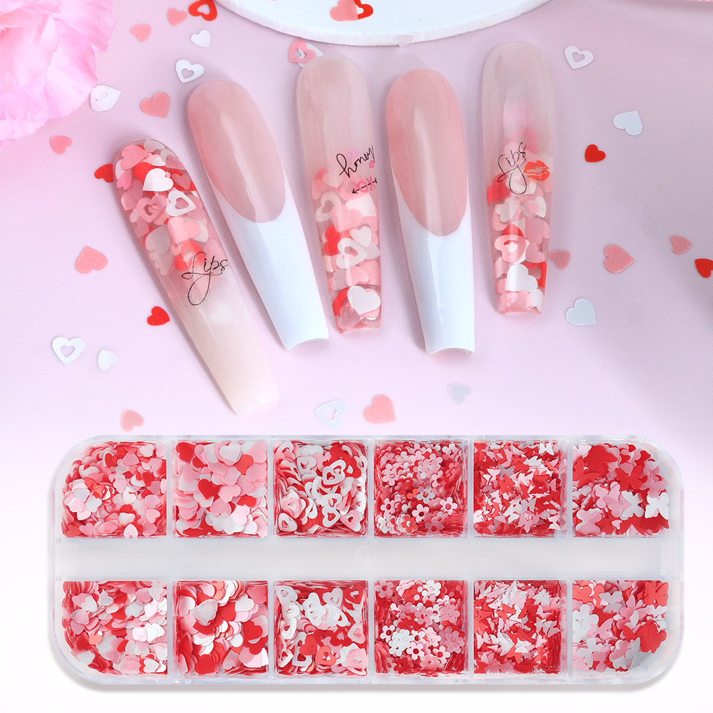 Caja de 12 compartimentos con accesorios perlados para decoración de uñas en forma de corazón, lentejuelas para uñas con diseño de mariposas y flores en rosa y blanco para el Día de San Valentín, decoraciones coloridas.