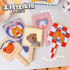 Cute cartoon handheld makeup mirror for girls, portable and small, with a handle, also known as a beauty mirror or cosmetic mirror.
