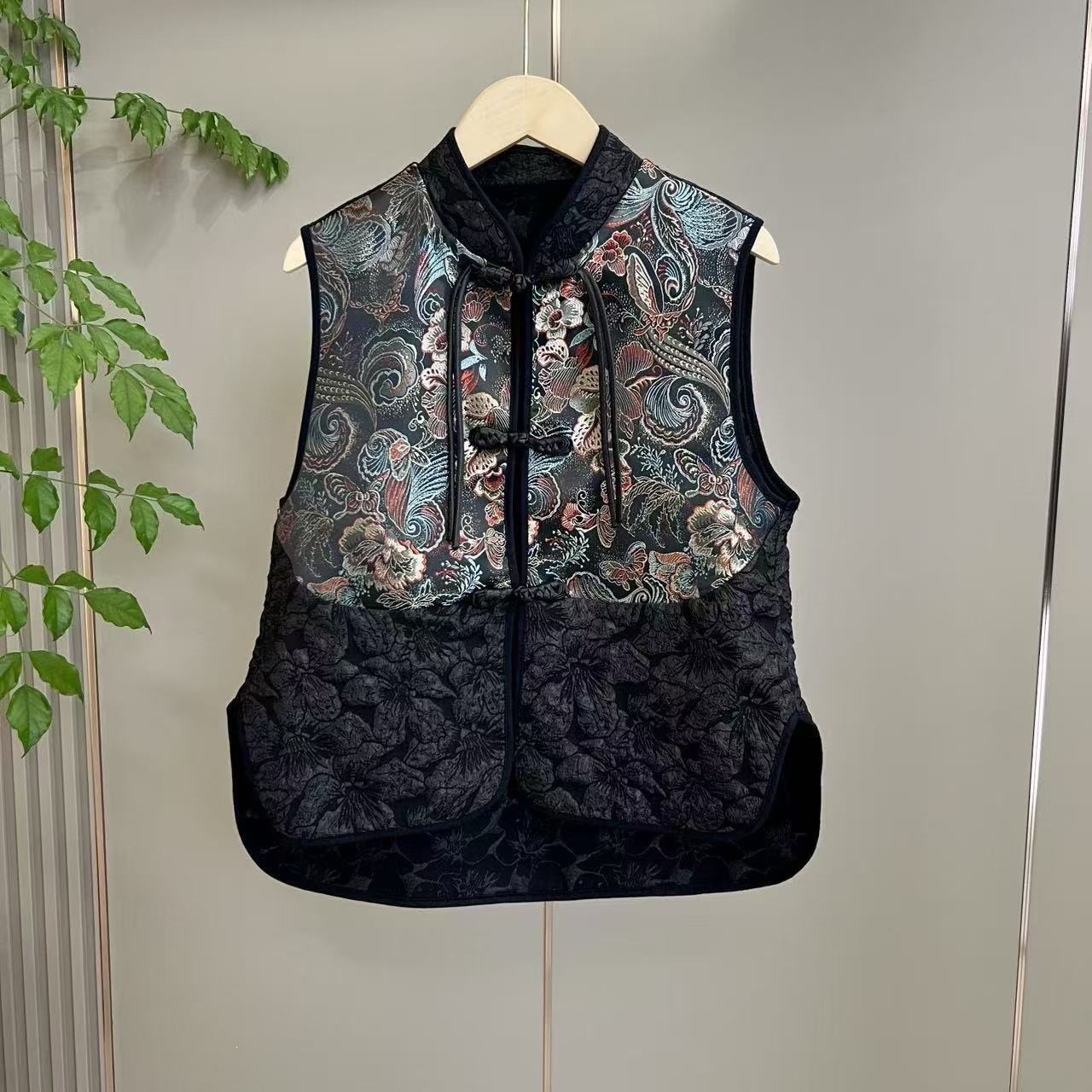 A complete set of traditional Chinese style jacquard embroidered vest with ethnic knot buttons and retro black wide-leg straight casual pants.