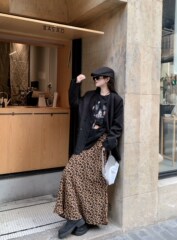 ファッションスーツの女性の高級感がゆったりしている黒いスーツのコートは腰が高くて痩せています。