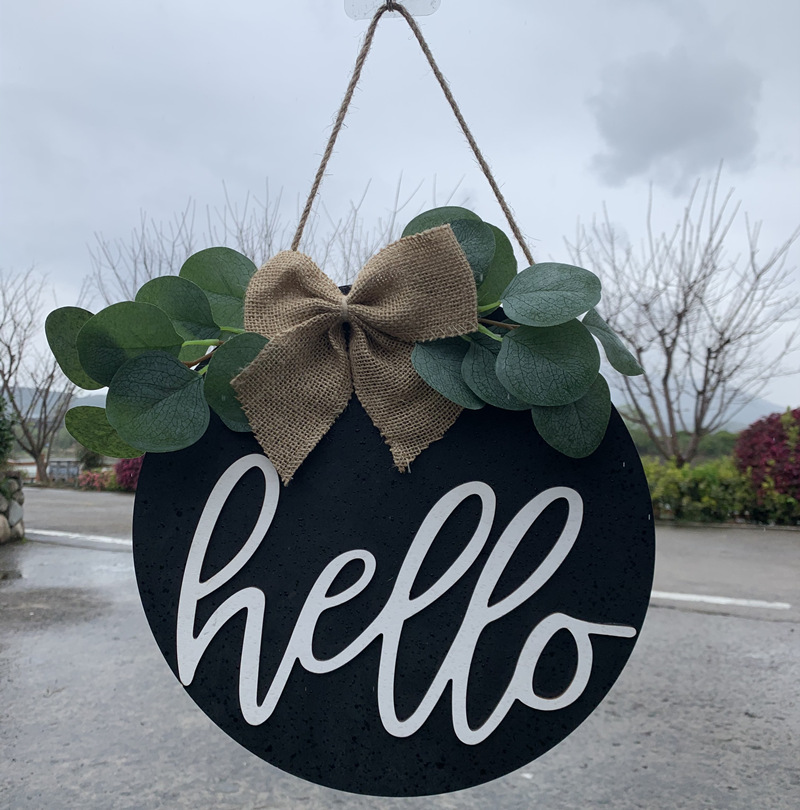 Olá estilo rural. A decoração circular inacabada da porta da frente recebe etiquetas e placas de madeira penduradas_voghion.com