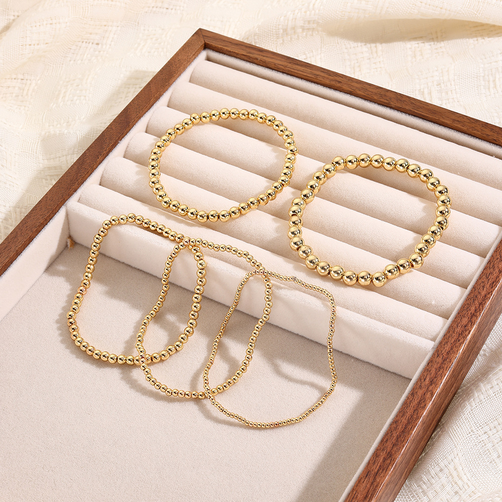 Bracciale da donna in oro 18 carati con perline di rame e bracciale elastico. Set di bracciali._voghion.com