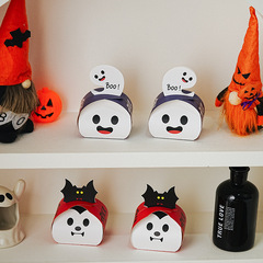 ハロウィーンのテーマパーティーの包装の手は箱の幽霊のコウモリの金のクッキーの雪のショートニングの贈り物の箱の包装箱を持ちます。