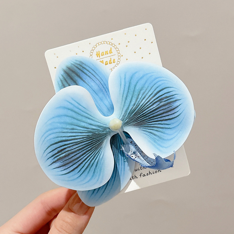 Chica caliente con flores naranjas orquídeas mariposa clips de cabello vacaciones fotos atmósfera clips de cabello