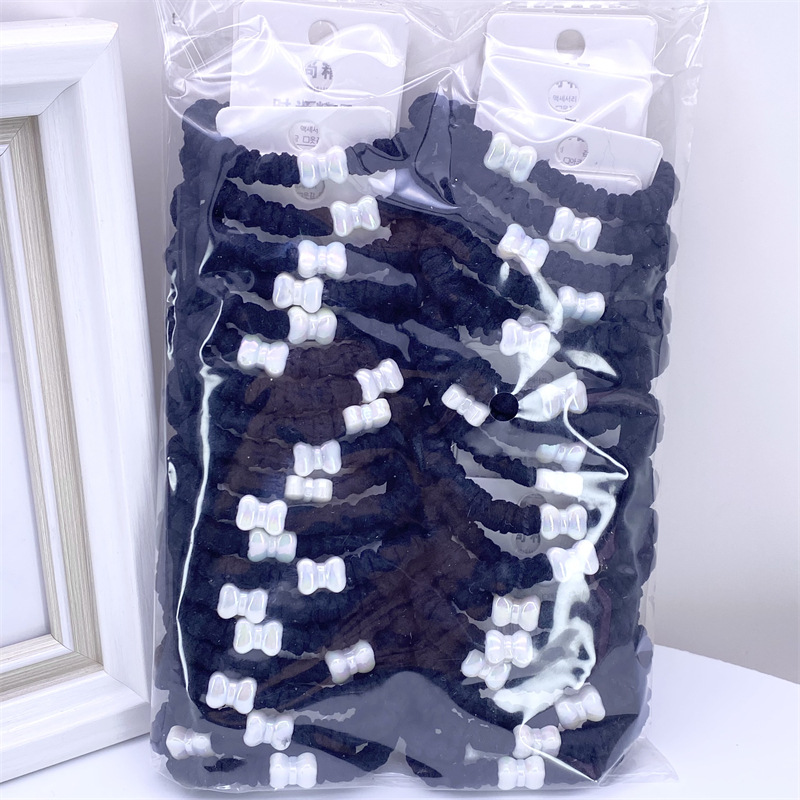 Etiqueta de estilo coreano accesorios para el cabello para niños Perla pequeña pajarita cuerda de pelo chica estudiante cabeza cuerda banda de goma dos yuanes suministro de la tienda