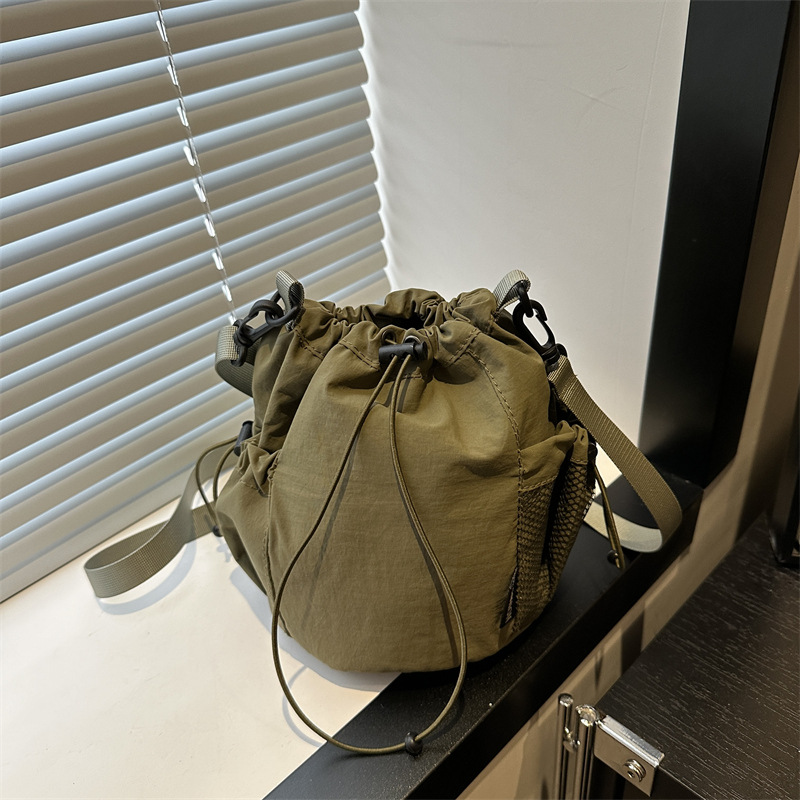 2025 verano nuevo nicho japonés y coreano tirar de la correa de tela de un hombro mochila de mujer ligera perezosa bolsa de cubo de feng shui