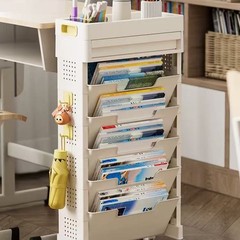 机の端の本棚の高校生は床に落ちて小さい物置棚の学生の教室の学習の机の側の本を置いて移動します。