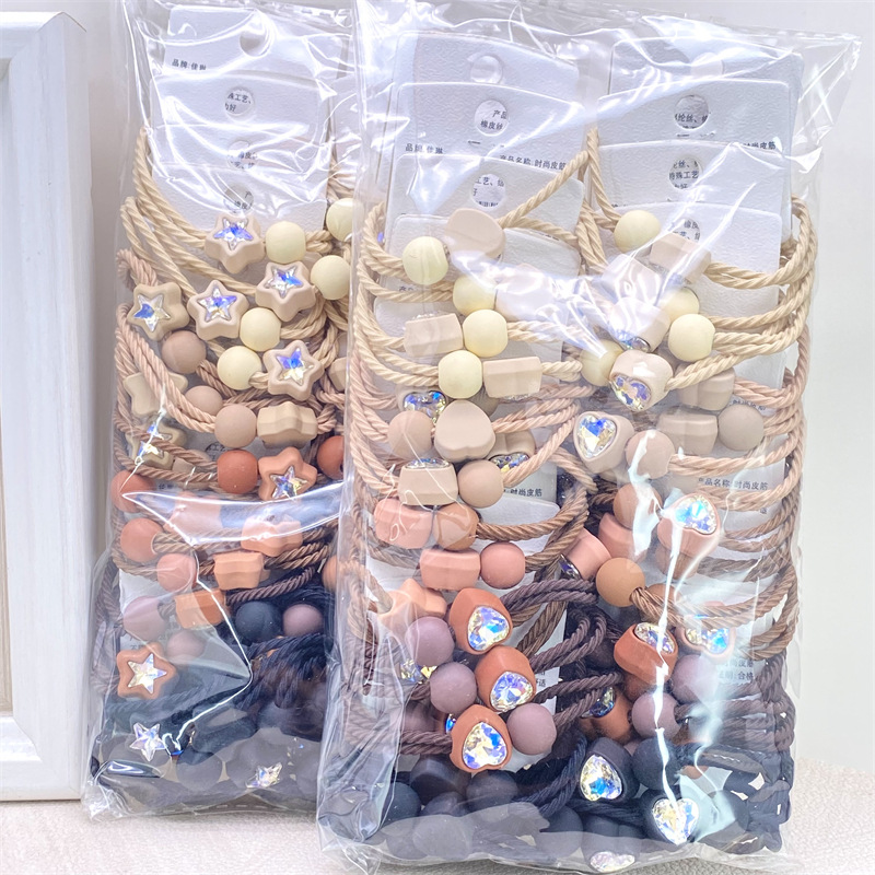 Etiqueta de estilo coreano accesorios para el cabello para niños Perla pequeña pajarita cuerda de pelo chica estudiante cabeza cuerda banda de goma dos yuanes suministro de la tienda