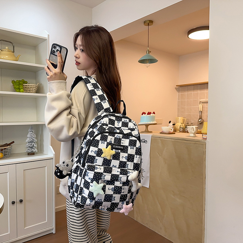 Los nuevos estudiantes de secundaria son ligeros y llevan la versión coreana de la mochila de hombro femenino. los estudiantes del campus de gran capacidad tienen mochilas de moda.