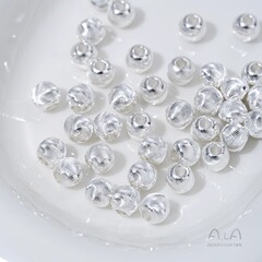 銀メッキの花の細い紋様がきらきらと光る猫の目の切断面の丸い玉は線を引いて玉の部品の手作りのdiyの真珠の水晶の材料をつなぎます。