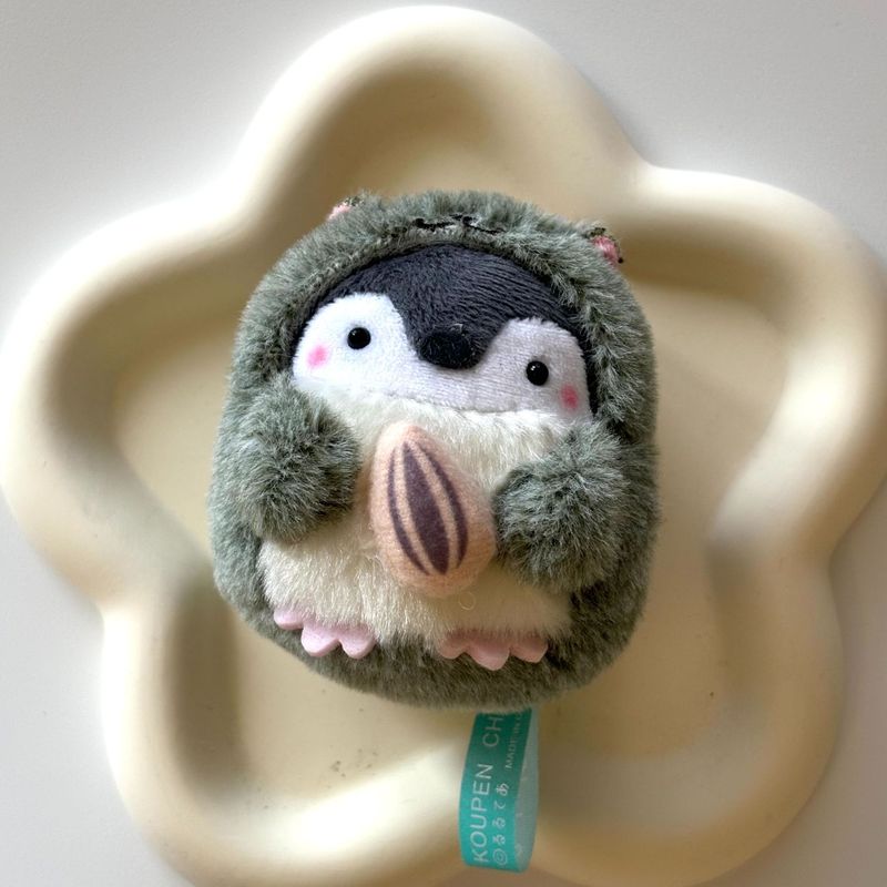 日系かわいい正エネルギーペンギンがかじっているハムスターペンギンのぬいぐるみのかばんにキーホルダーをつけている|undefined