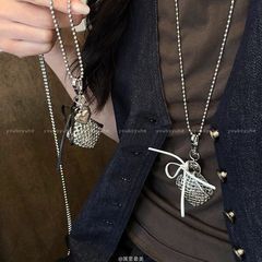 銀色の愛のリボンを編んでネックレスの女性を包みます。