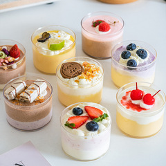 丸いデザートのムースカップの四角い蓋付きティラミスの木の糠カップの硬いプラスチックの果物のクリームはテーブルのケーキのカップを並べます。