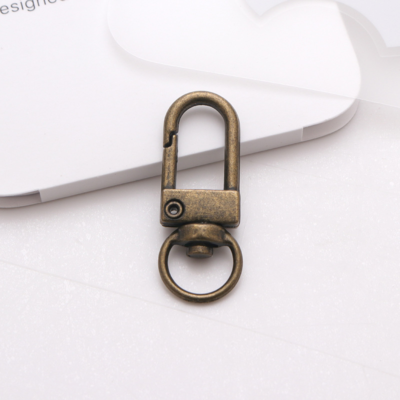 ドアボタンのキーホルダーの金属部品の回転犬は亜鉛合金のアクセサリーを掛けます。