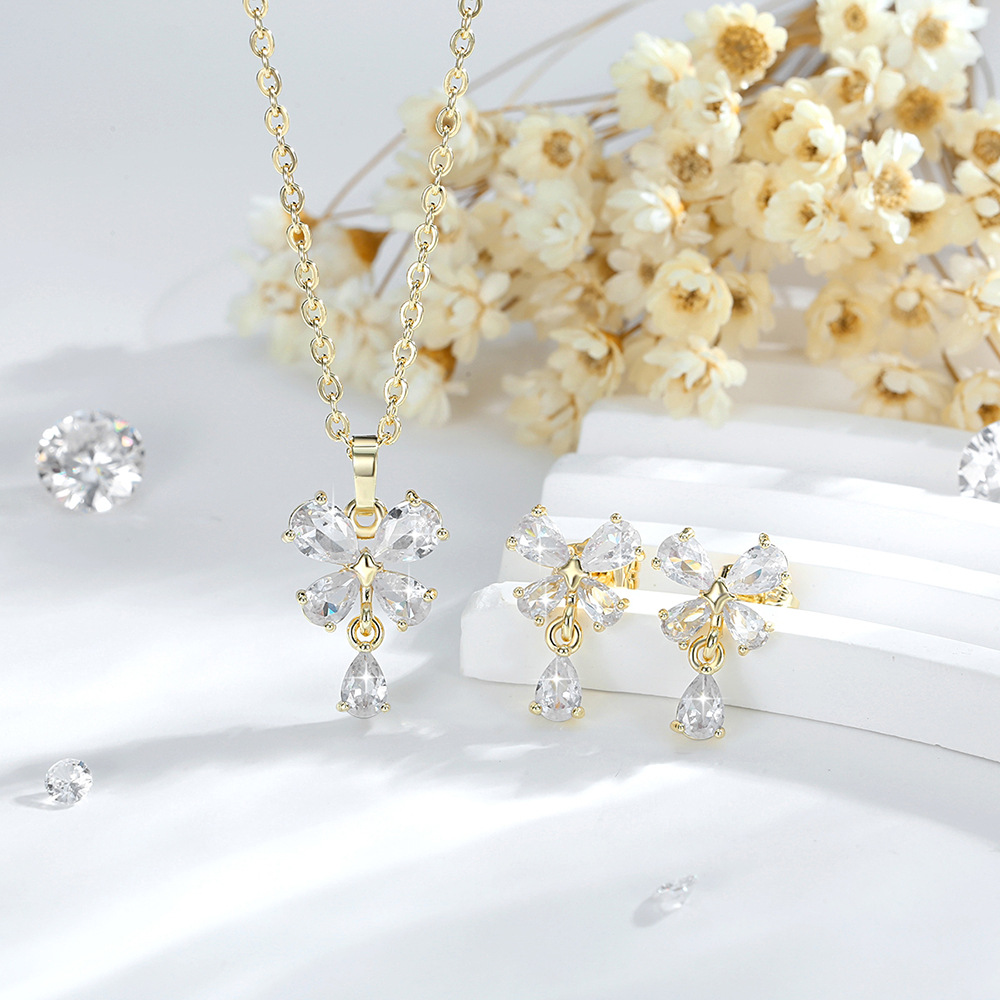 Exquisito conjunto de adornos de flores de cuatro hojas de diseño de moda transfronterizo cobre chapado en oro 14K colgante de flores de zircon aretes