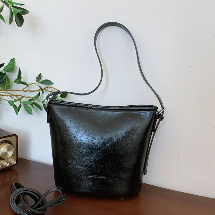 Bolsos de mano retro de alta textura para mujeres 2025, nuevos bolsos de hombro de moda simples, bolsos de cubo de transporte universal