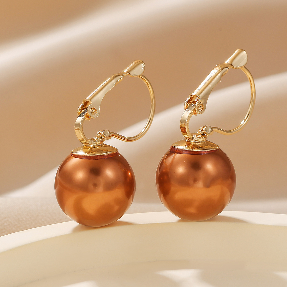 Moderne perleøreringe med kobberfarvede metalclips_voghion.com