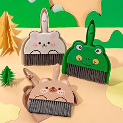 机の上のミニの小さいほうきのセットのテーブルの掃除道具の小さいほうきの机の上の子供の小学生は箕の組み合わせを使います。