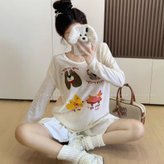杏色のアニメのプリントのデザイン感の長袖tシャツの女性の早秋の怠惰な風がゆったりしています。