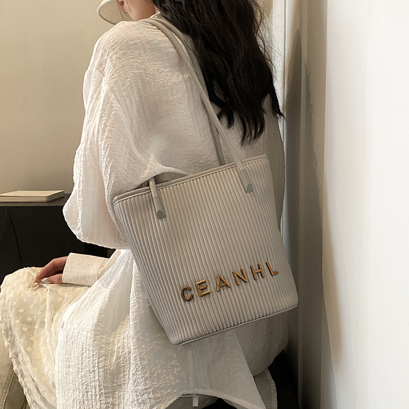 2025 otoño y invierno nuevo pequeño bolso a rayas de viento fragante bolso de cubo simple bolso de hombro de tendencia de mujeres bolso de mochila popular