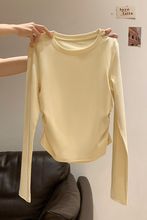 奶黄色慵懒风圆领下摆不规则长袖t恤女早秋短款褶皱修身打底上衣