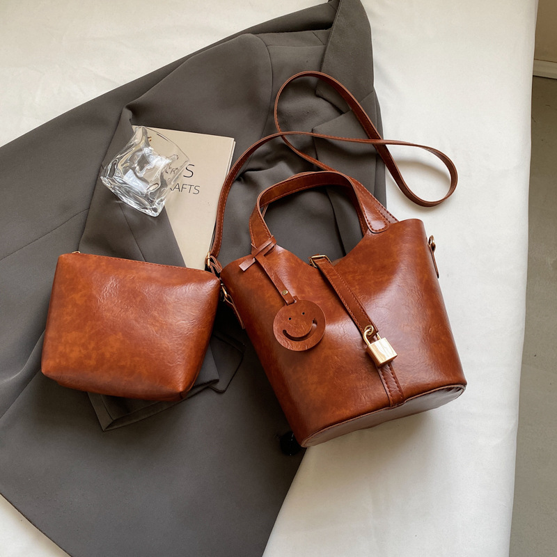 Bolso retro versátil para mujeres 2024 moda nuevo bolso de cubo de mano alta textura de transporte aéreo bolso de mochila