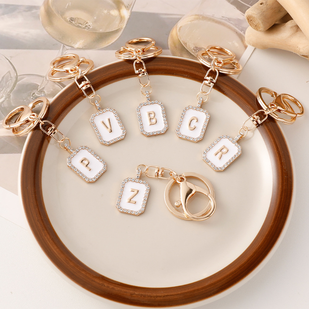 Nueva moda 26 cartas gota de diamante aceite llavero bolso del auricular pareja colgante vacaciones pequeño regalo al por mayor