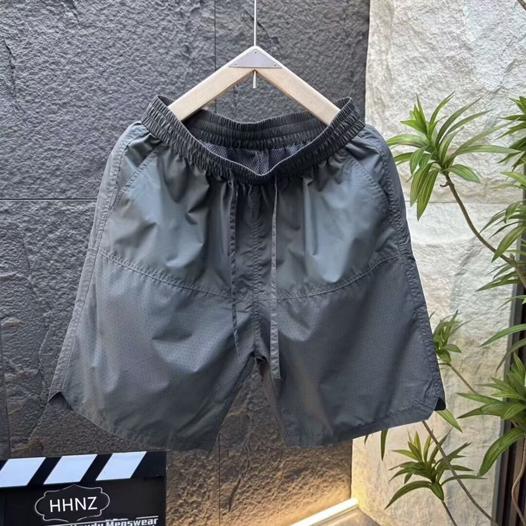 Verano nuevo estilo láser perforado transpirable pantalones cortos casuales hombres simples y de moda todo fósforo sueltos de seda de hielo de secado rápido pantalones de cinco puntos