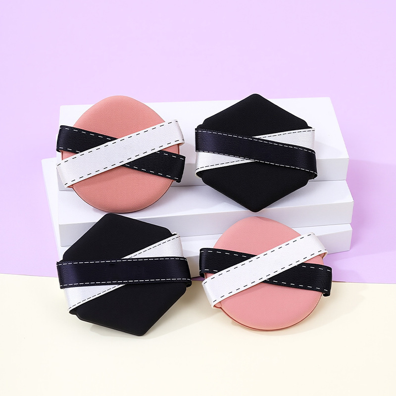 La borla de polvo de cinta de dos colores personalizada de fábrica no come polvo, gotas de agua sin látex, esponja de maquillaje de seis lados en forma de diamante, cojín de aire al por mayor