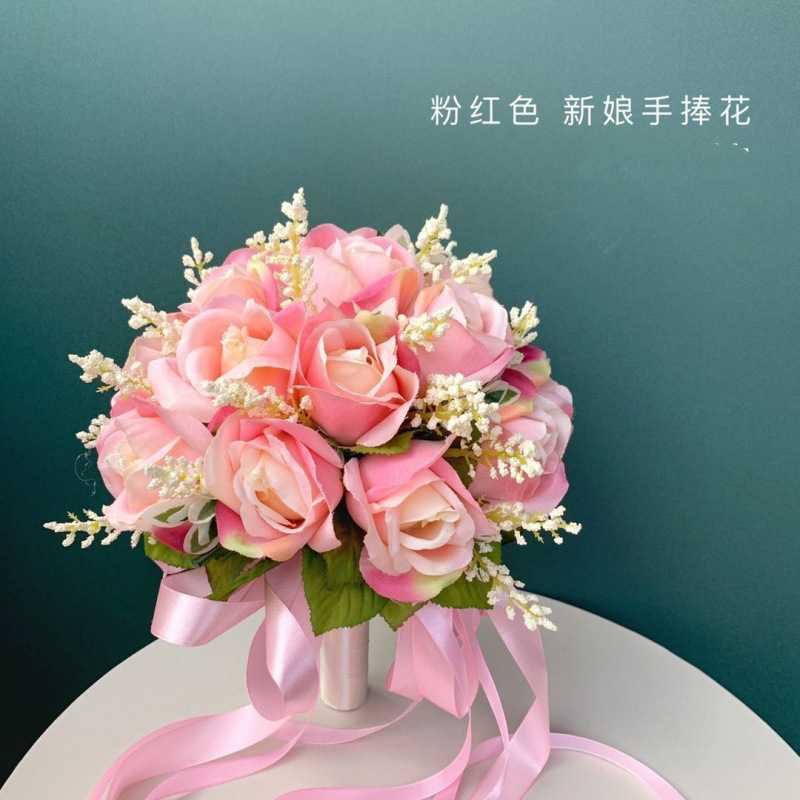 手に花を持つ新婦の韓国式結婚式の領収書のシミュレーションの花束の森系のウェディングドレスの撮影の道具の手に花をささげます。|undefined