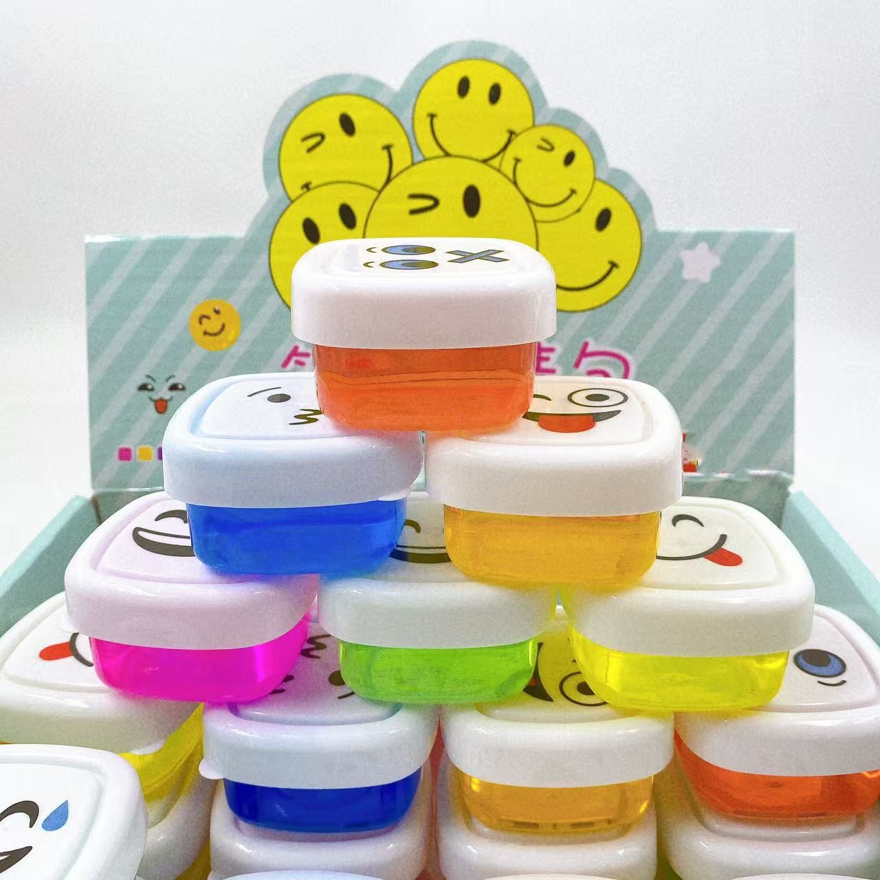 Nuevo paquete de emoticonos de cara sonriente de 24 entrada, pegamento espumoso, lodo de color slime, pegamento M, arcilla de cristal, juguetes para niños de bricolaje al por mayor