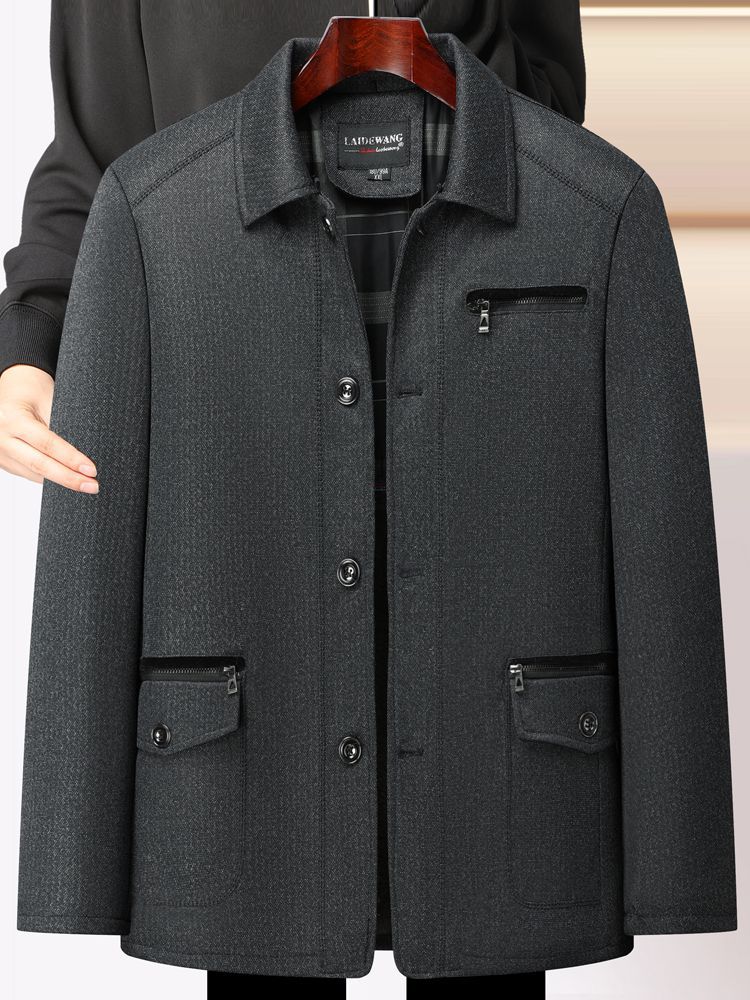 秋冬の中高年のメンズとベルベットのコートのお父さんはビジネス服の中年の男性の厚いジャケットの上着を襟を返します。