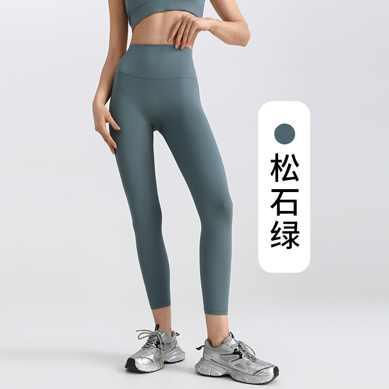 ヨガのズボンの女性は腹を収めて尻を持ちます。|undefined