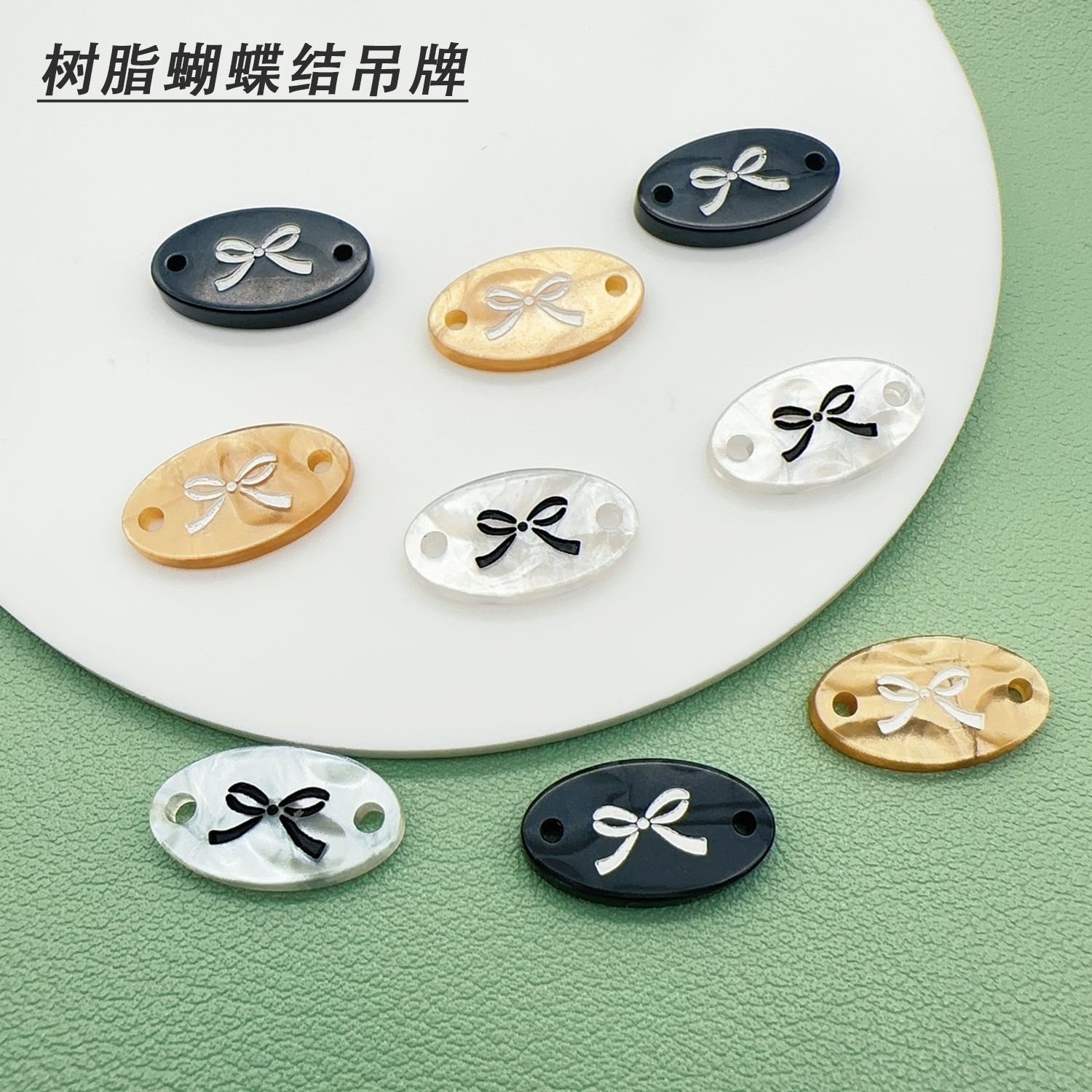 现货树脂仿贝吊牌纽扣椭圆蝴蝶结钮扣商标字母装饰品扣子百搭时尚