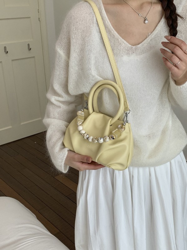 Alta sensación de mano pliegueada nube bolso de cubo para mujeres 2026 nuevo nicho de lujo ligero de moda perla bolsa de mochila