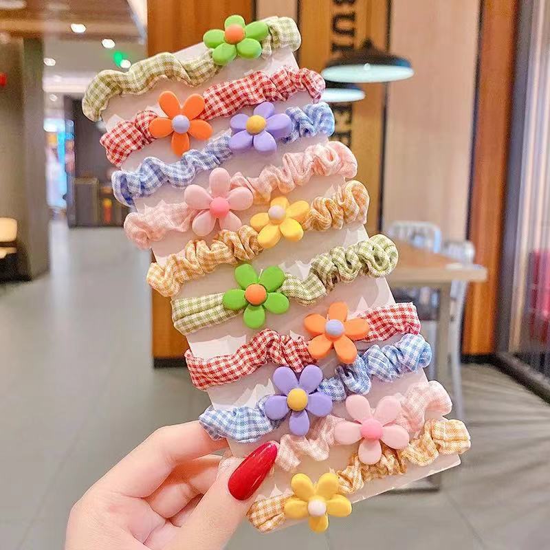 韓国の甘い子供の小腸の輪がかわいい女の子は頭のゴムのひもを刺して髪の弾力性を傷つけません。|undefined