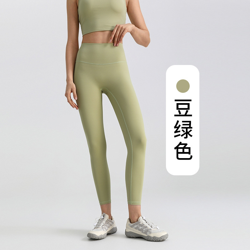 ヨガのズボンの女性は腹を収めて尻を持ちます。|undefined