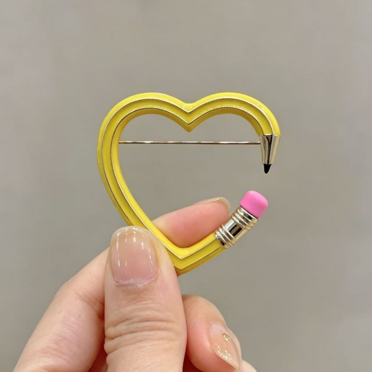 Cross-border best-selling creative heart-shaped pencil brooch, fun hollow-out enamel pin, niche cute item available for wholesale