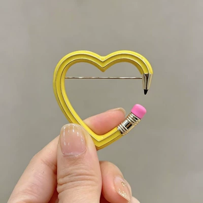 Cross-border best-selling creative heart-shaped pencil brooch, fun hollow-out enamel pin, niche cute item available for wholesale (Yaxa sancaqları) - yellow