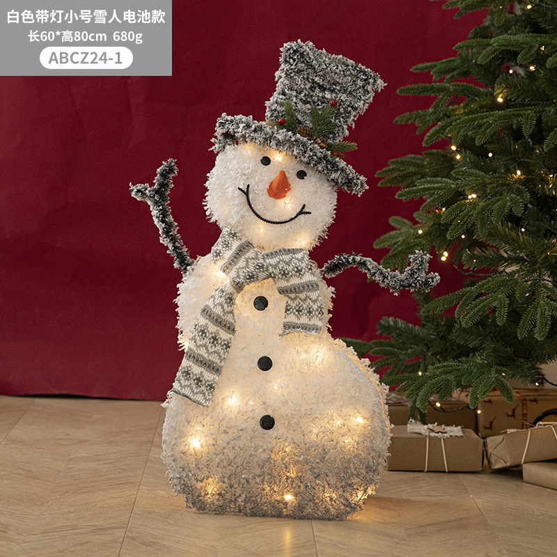 Decoraciones navideñas de muñecos de nieve, adornos de escaparate con una escena de renos de peluche blancos brillantes para la Nochebuena.