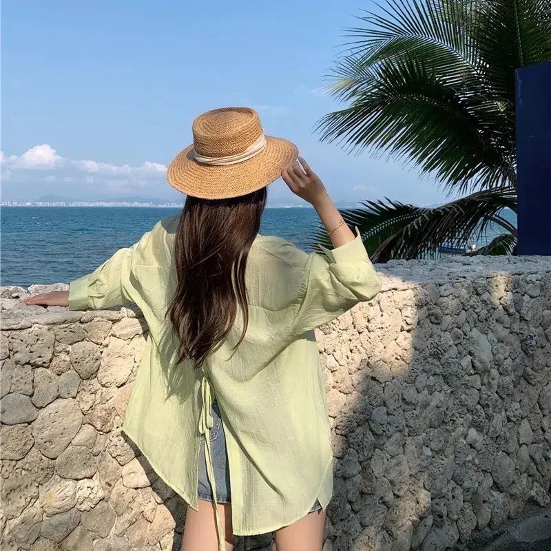 薄いタイプの微透長袖日焼け止めカーディガンの背中には、青いシャツ付きの女性夏のファッションカジュアルシャツのコートがあります。|undefined